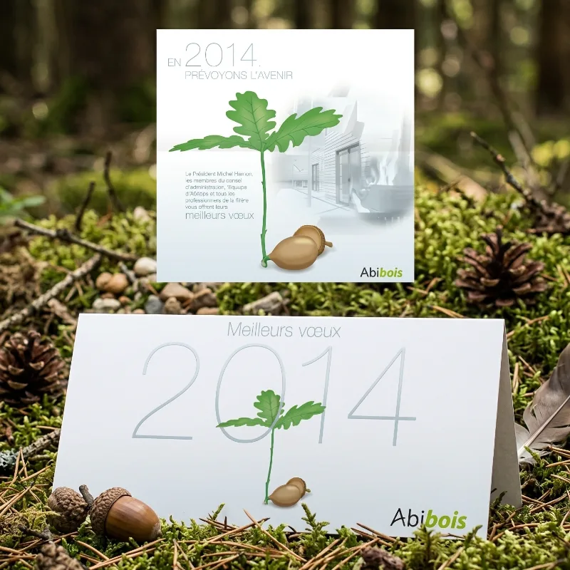 Carte de vœux Abibois illustrée d'une jeune pousse de chêne et d'un gland posée en sous-bois